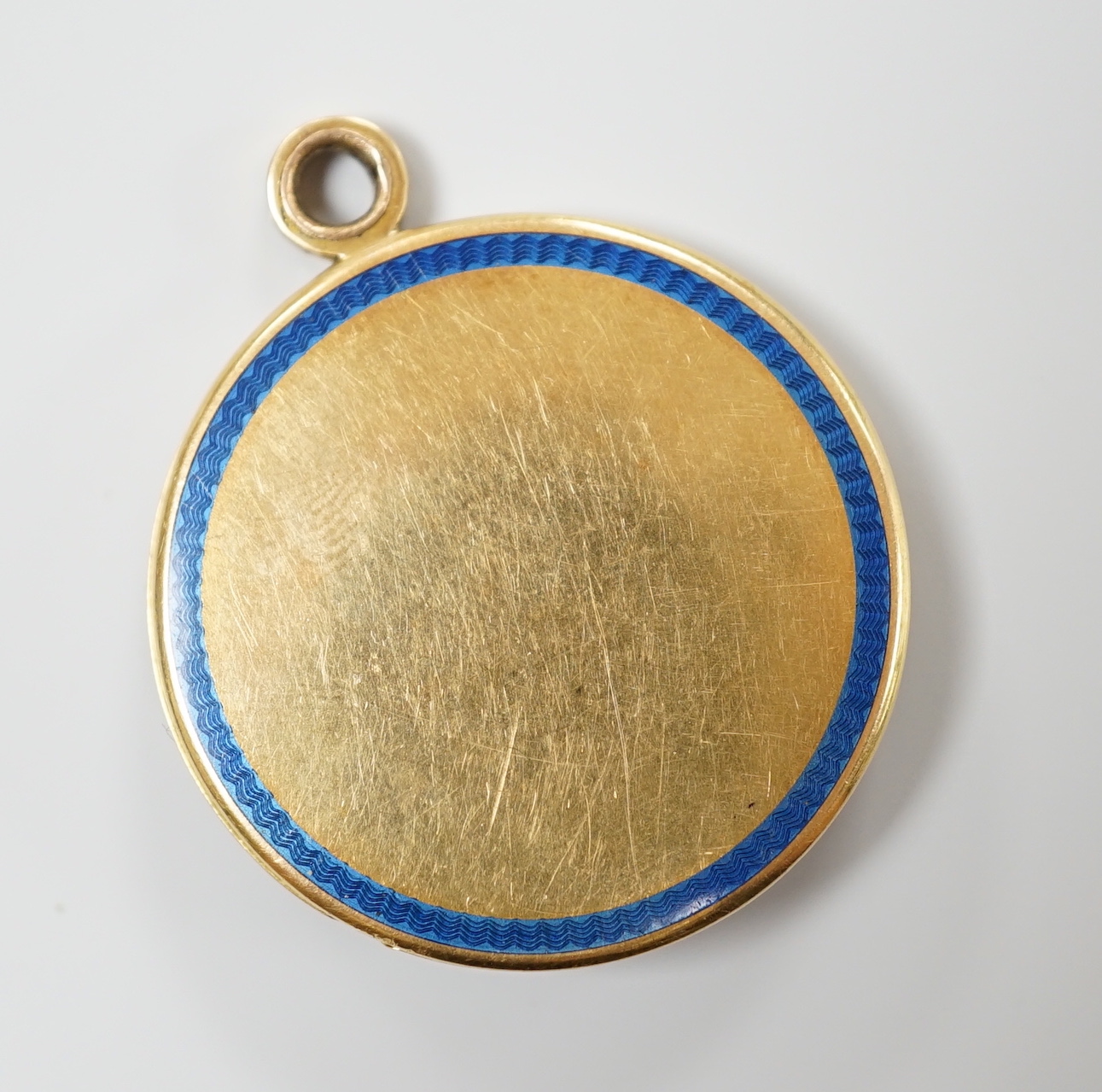 An Art Deco yellow metal, three colour enamel, synthetic? sapphire and diamond set circular locket, with clover motif, diameter 29mm